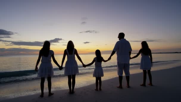 Familia caucásica disfrutando de vacaciones en la playa al atardecer — Vídeos de Stock