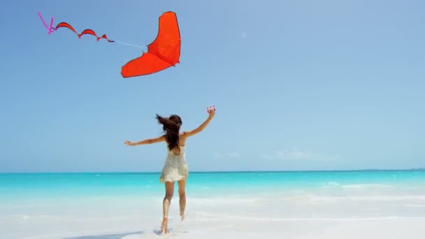 Chica asiática jugando con cometa roja en la playa — Vídeos de Stock