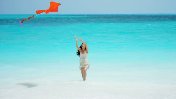 Asyalı kız ile kırmızı uçurtma sahilde oynarken — Stok video