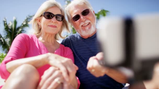 Pareja mayor tomando selfie en la playa — Vídeos de Stock