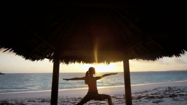 Молодая девушка практикует йогу на пляже — стоковое видео