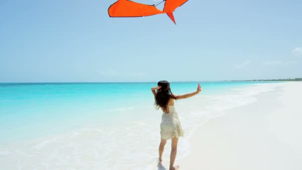 Asian girl playing with red kite on beach — Stock Video