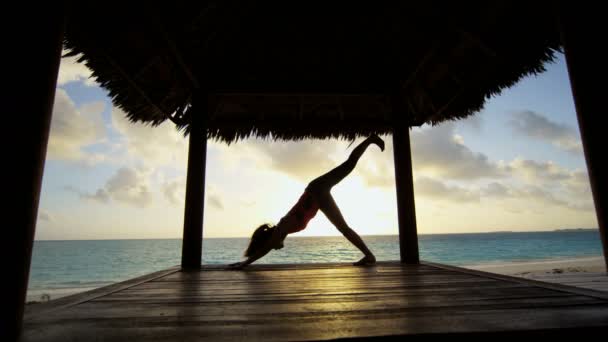 Jong meisje beoefenen van yoga op het strand — Stockvideo