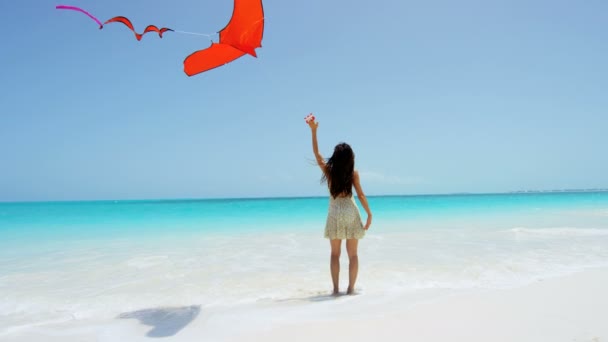 Asian girl playing with red kite on beach — Stock Video