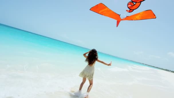 Asian girl playing with red kite on beach — Stock Video