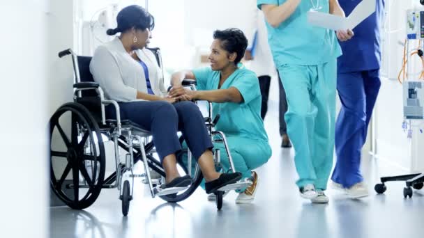 Женщина-медсестра и пациент на инвалидной коляске в больнице — стоковое видео