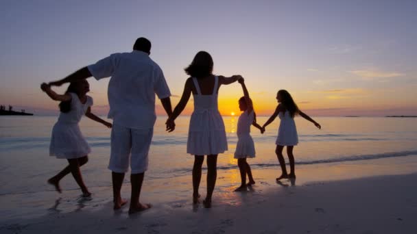 Familia caucásica disfrutando de vacaciones en la playa al atardecer — Vídeos de Stock