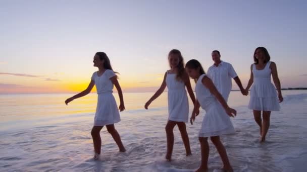 Familia caucásica disfrutando de vacaciones en la playa al atardecer — Vídeo de stock