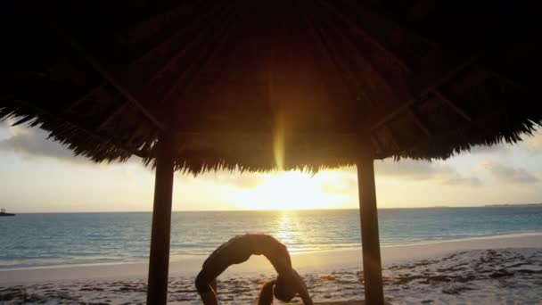 Young girl practicing yoga on the beach — Stock Video