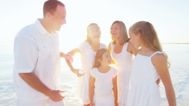 Família caucasiana desfrutando de férias na praia ao pôr do sol — Vídeo de Stock