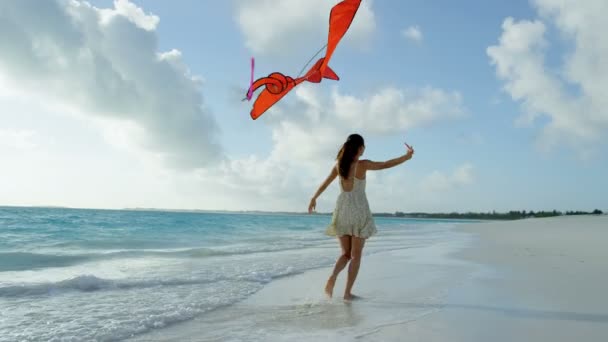 Азіатська дівчинка, граючи з червоним кайт на пляж — стокове відео