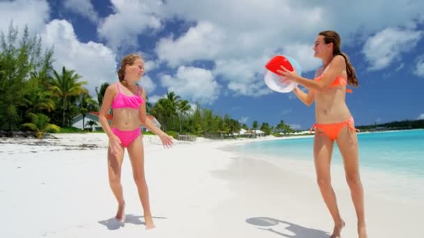 Молодые девушки играют с мячом на пляже — стоковое видео