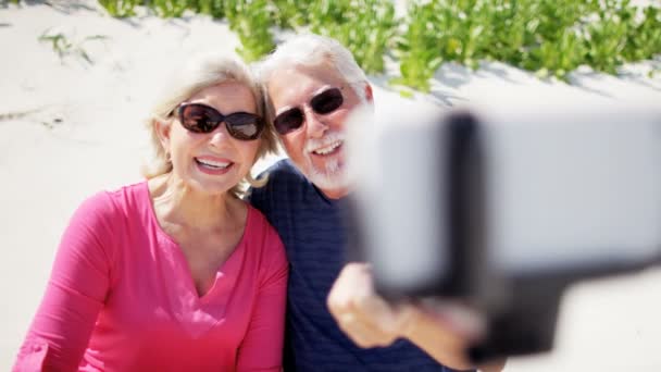 Pareja mayor tomando selfie en la playa — Vídeos de Stock