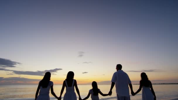 Familia caucásica disfrutando de vacaciones en la playa al atardecer — Vídeos de Stock