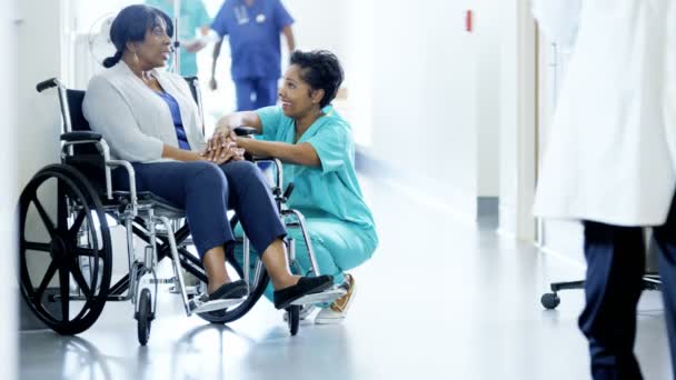 Жінка медсестра і пацієнтка на інвалідному візку в лікарні — стокове відео