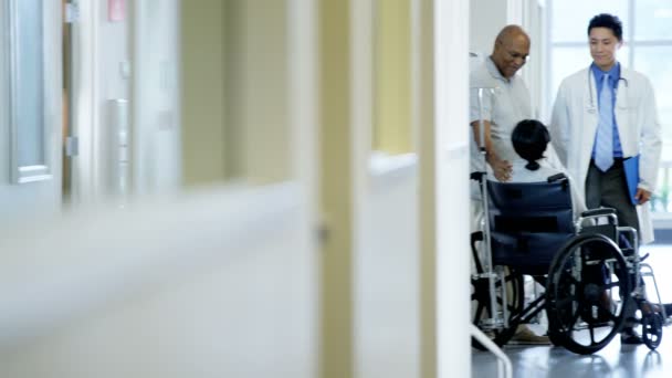 Kobieta na wózku inwalidzkim z mężem konsultuje się z lekarzem — Wideo stockowe