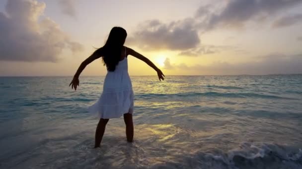 Chineză fată dansând pe plajă la apus de soare — Videoclip de stoc