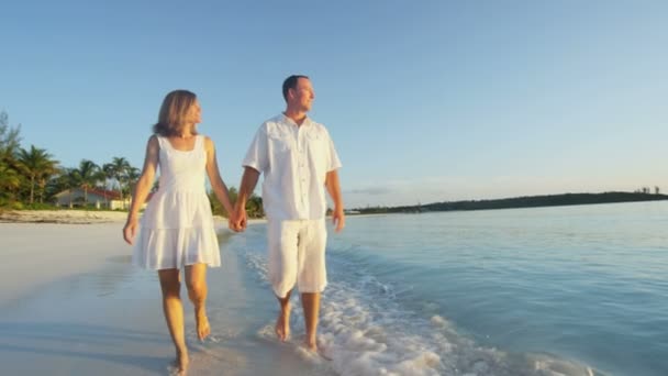 Caucásico pareja en tropical playa al atardecer — Vídeo de stock