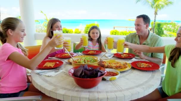 Familia caucásica disfrutando comiendo en la playa — Vídeos de Stock