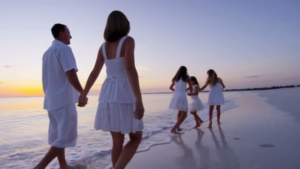 Familia caucásica disfrutando de vacaciones en la playa al atardecer — Vídeo de stock