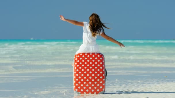 Bambina su una spiaggia seduta su una valigia — Video Stock