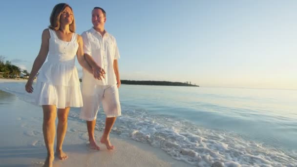 Caucásico pareja en tropical playa al atardecer — Vídeos de Stock