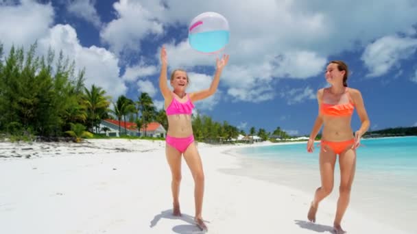 Молоді дівчата грають з м'ячем на пляжі — стокове відео