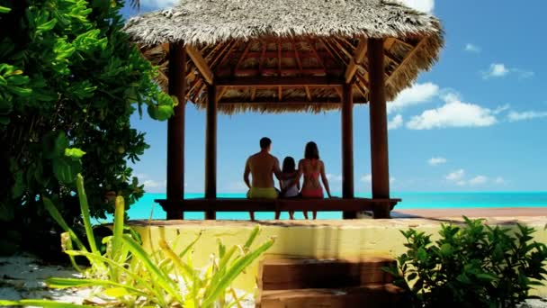 Familia en cabaña de paja tiki en la playa — Vídeo de stock