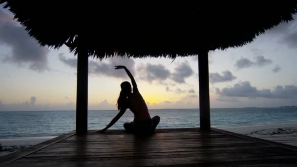 Chica joven practicando yoga en la playa — Vídeo de stock