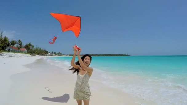 Chica asiática jugando con cometa roja en la playa — Vídeos de Stock