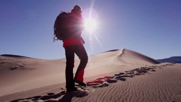 Explorador mujer caminando a través de dunas de arena — Vídeo de stock