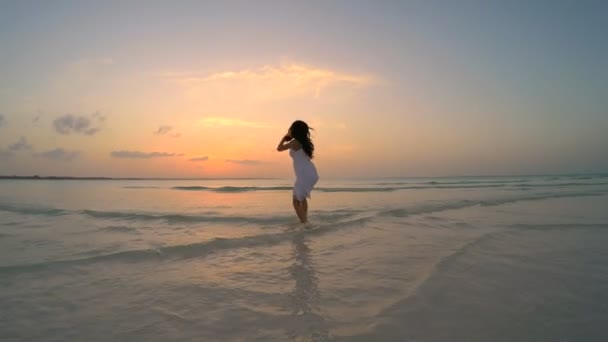 Китайська дівчина в Білій сукні танці на пляжі — стокове відео