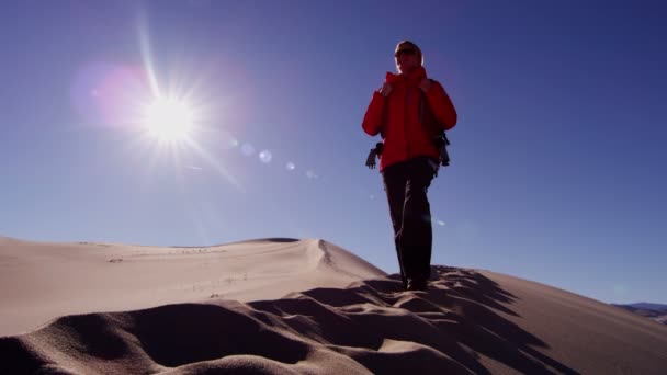 Woman explorer walking through sand dunes — Stock Video