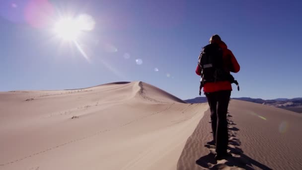 Kum tepeleri yürüyen kadın explorer — Stok video