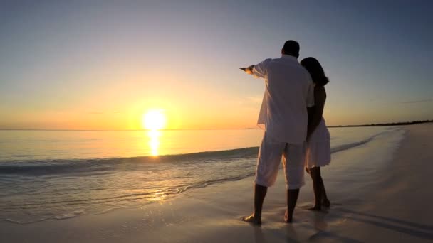 Caucásico pareja en tropical playa al atardecer — Vídeos de Stock