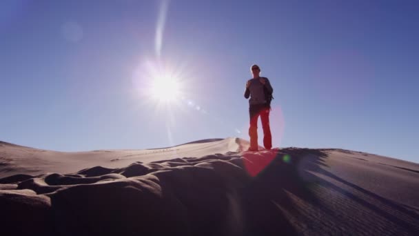 Mulher exploradora caminhando através de dunas de areia — Vídeo de Stock