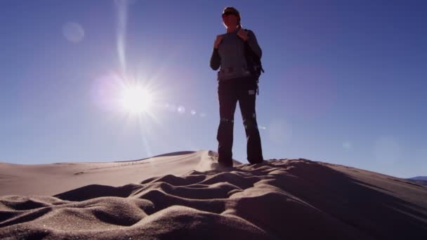 Explorador mujer caminando a través de dunas de arena — Vídeos de Stock