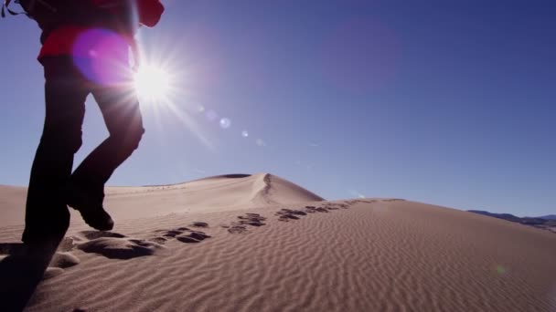 Woman explorer walking through sand dunes — Stock Video