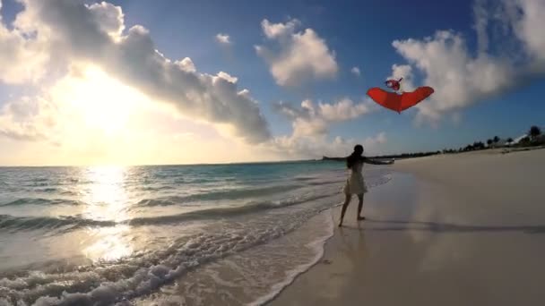 ผู้หญิงเอเชียเล่นกับว่าวสีแดงบนชายหาด — วีดีโอสต็อก