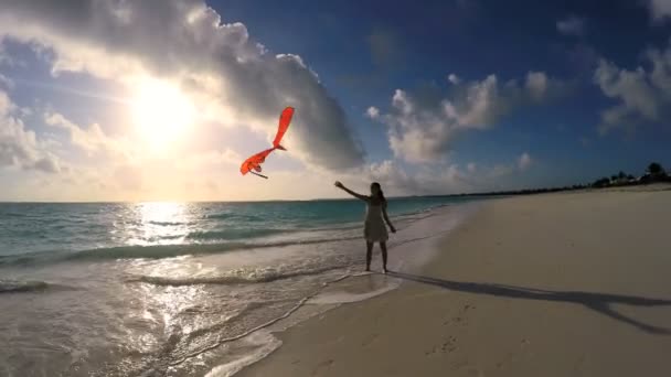 Ragazza asiatica che gioca con aquilone rosso sulla spiaggia — Video Stock