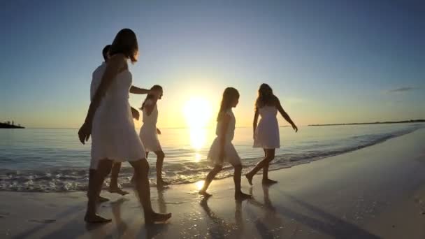 Família caucasiana desfrutando de férias na praia ao pôr do sol — Vídeo de Stock