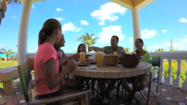 Família caucasiana desfrutando de comer na praia — Vídeo de Stock