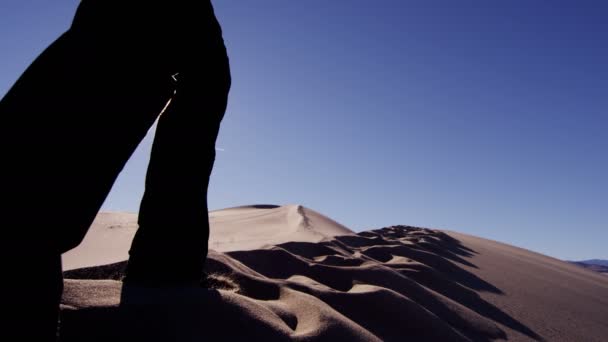 Жінка-дослідник, що йде через піщані дюни — стокове відео
