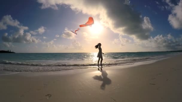 Азіатська дівчинка, граючи з червоним кайт на пляж — стокове відео