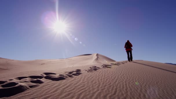 Explorador mujer caminando a través de dunas de arena — Vídeos de Stock