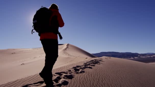 Explorador mujer caminando a través de dunas de arena — Vídeos de Stock
