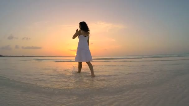 Chinees meisje in witte jurk dansen op strand — Stockvideo