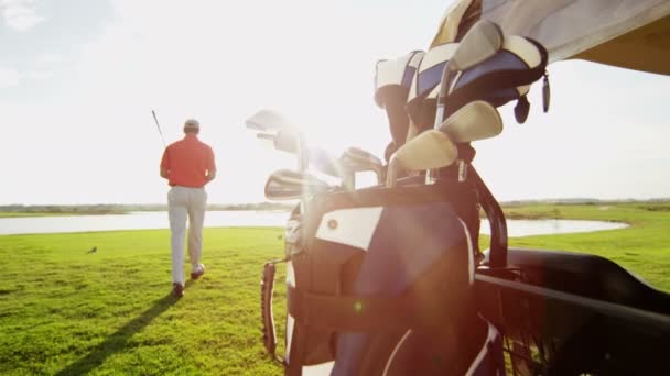 Jogador de golfe masculino profissional e carrinho de golfe com equipamento — Vídeo de Stock