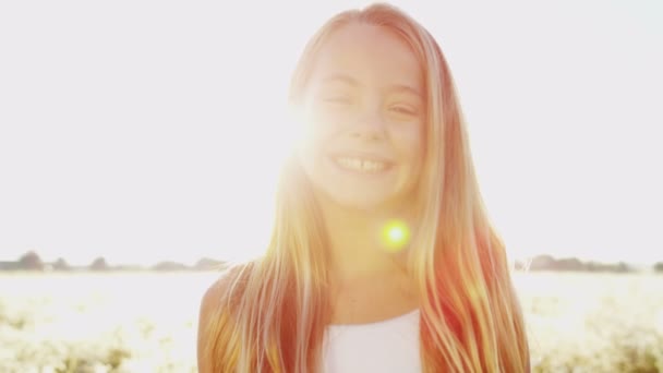 Uśmiechnięta młoda dziewczyna na zewnątrz w łące — Wideo stockowe