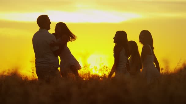 Parents avec leurs filles dans la prairie au coucher du soleil — Video